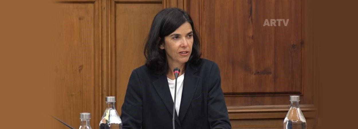 presidente da AdC sentada em mesa de audição parlamentar com microfone