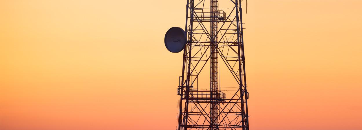 Torre de telecomunicações sobre fundo de céu laranja