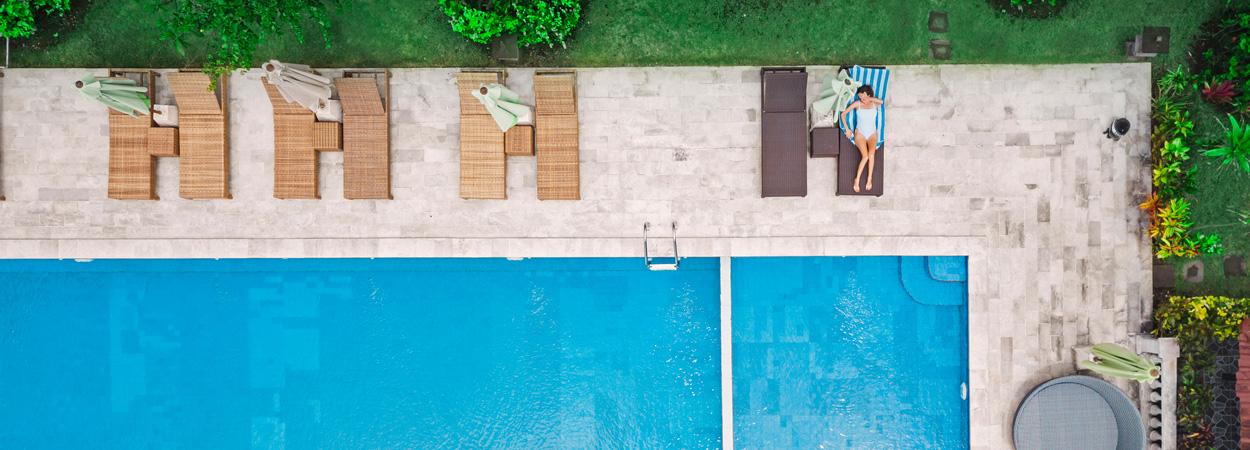 parte de piscina inserida em jardim com espreguiçadeiras