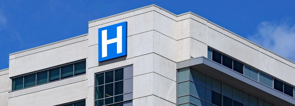 Parte superior de fachada de edifício hospitalar identificado pela letra H 