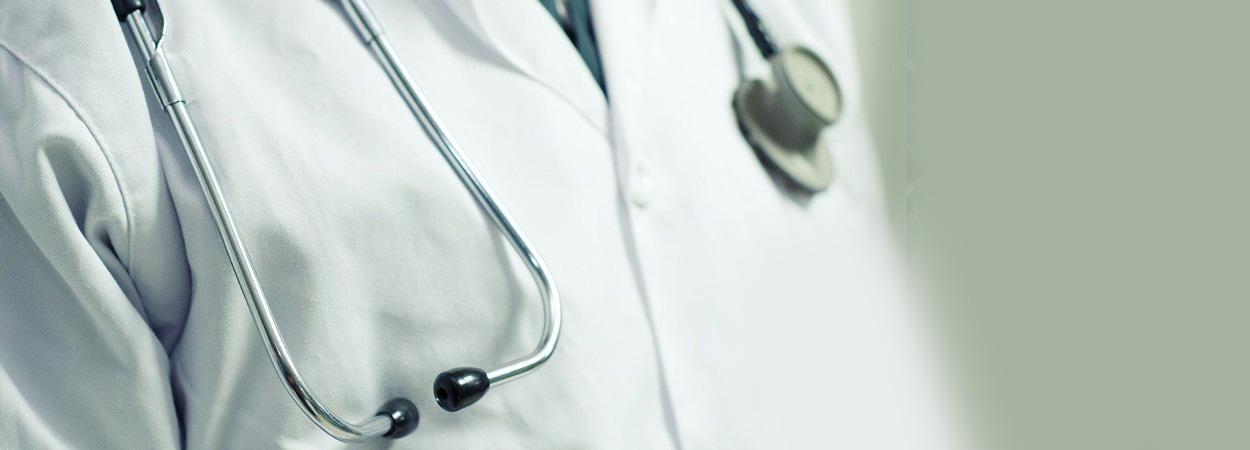 torso de homem com bata branca usando estetoscópio ao pescoço