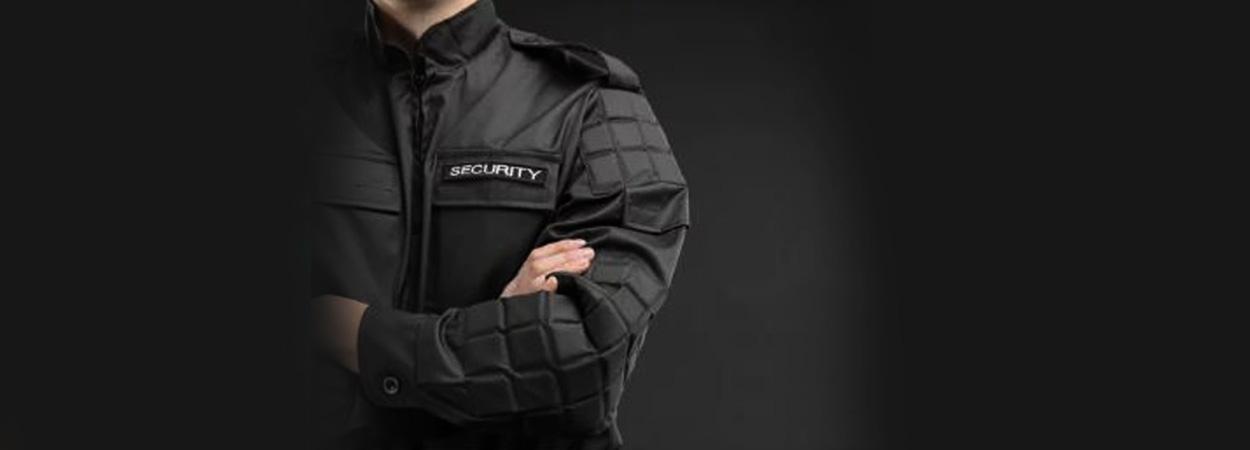 fundo negro com homem usando blusão identificado com a palavra security
