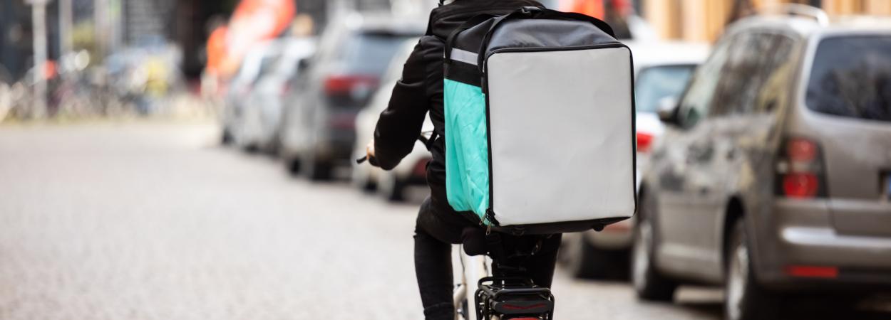 homem em bicicleta com mochila de entregas