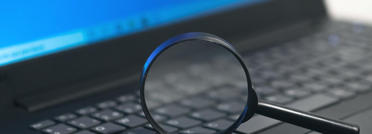 lupa sobre o teclado de um computador portátil