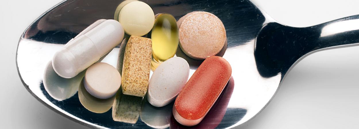 colher com comprimidos de suplementos alimentares
