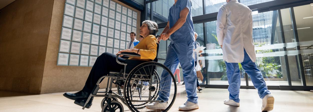 mulher em cadeira de rodas em átrio de hospital
