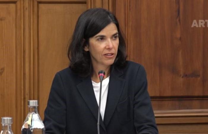 presidente da AdC sentada em mesa de audição parlamentar com microfone