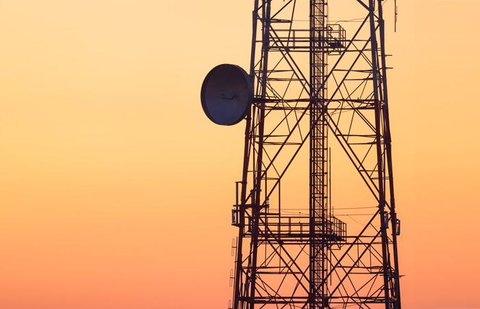Torre de telecomunicações sobre fundo de céu laranja