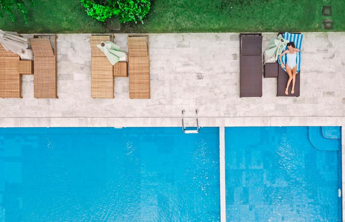 parte de piscina inserida em jardim com espreguiçadeiras