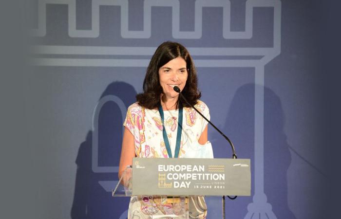 presidente da AdC discursando num púlpito identificado com o símbolo do Dia Europeu da Concorrência em Lisboa