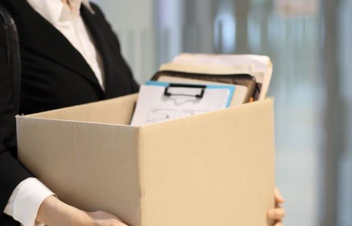 mulher com caixa saindo de escritório