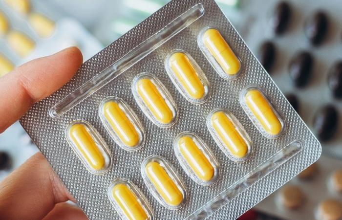 mão segurando plaqueta de comprimidos