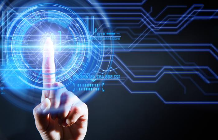 mão feminina a tocar em ecrã com circuitos iluminados