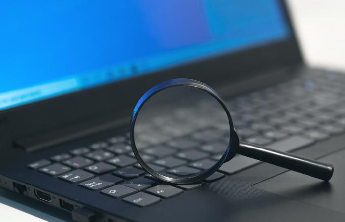 lupa sobre o teclado de um computador portátil