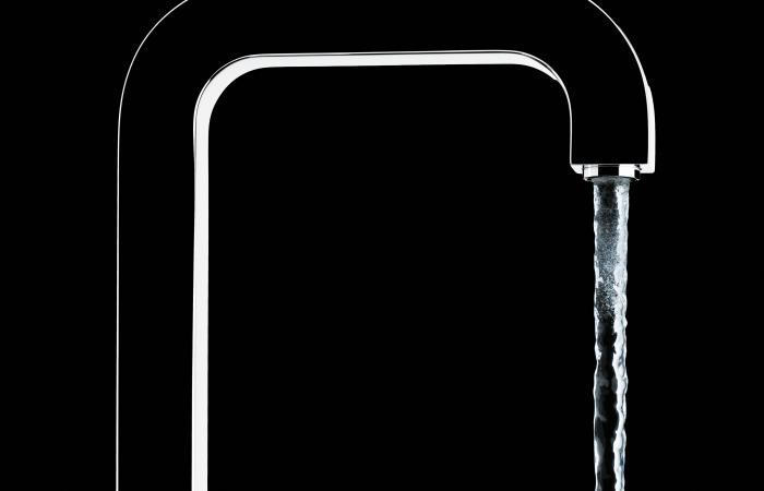 água a correr de torneira em fundo negro 