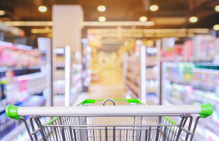 carrinho de compras em frente a corredor de supermercado