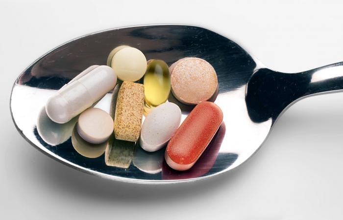 colher com comprimidos de suplementos alimentares