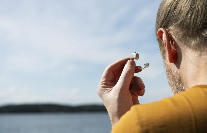 Homem colocando aparelho auditivo